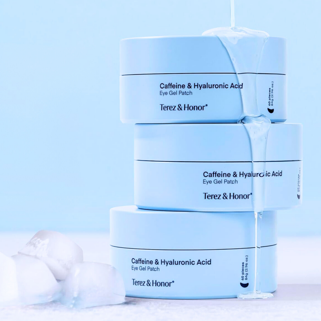 Stack of Terez & Honor caffeine and hyaluronic acid eye gel patch boxes on a light blue background.
